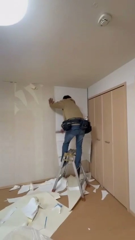 クロス張り替えの施工前。古いクロスを剥がしている状態